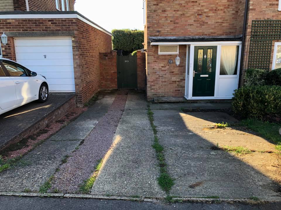 Before: a cracked concrete driveway with weeds growing through the joints
