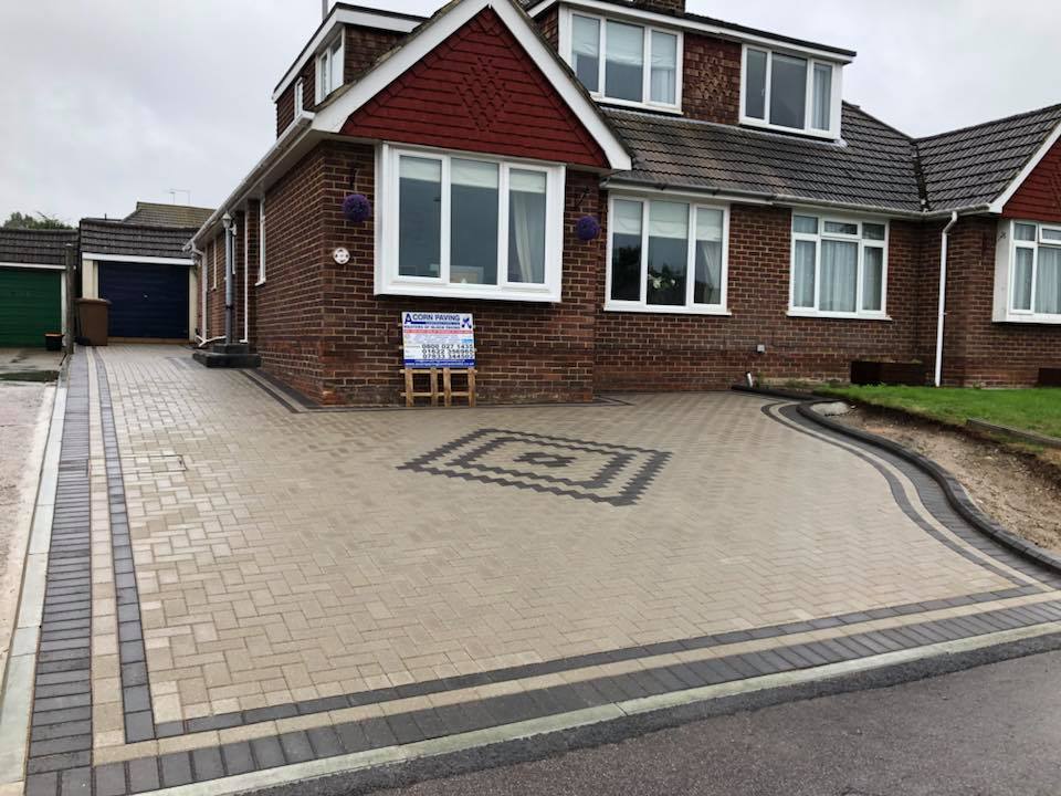 Buff block paved driveway with a charcoal diamond centre feature