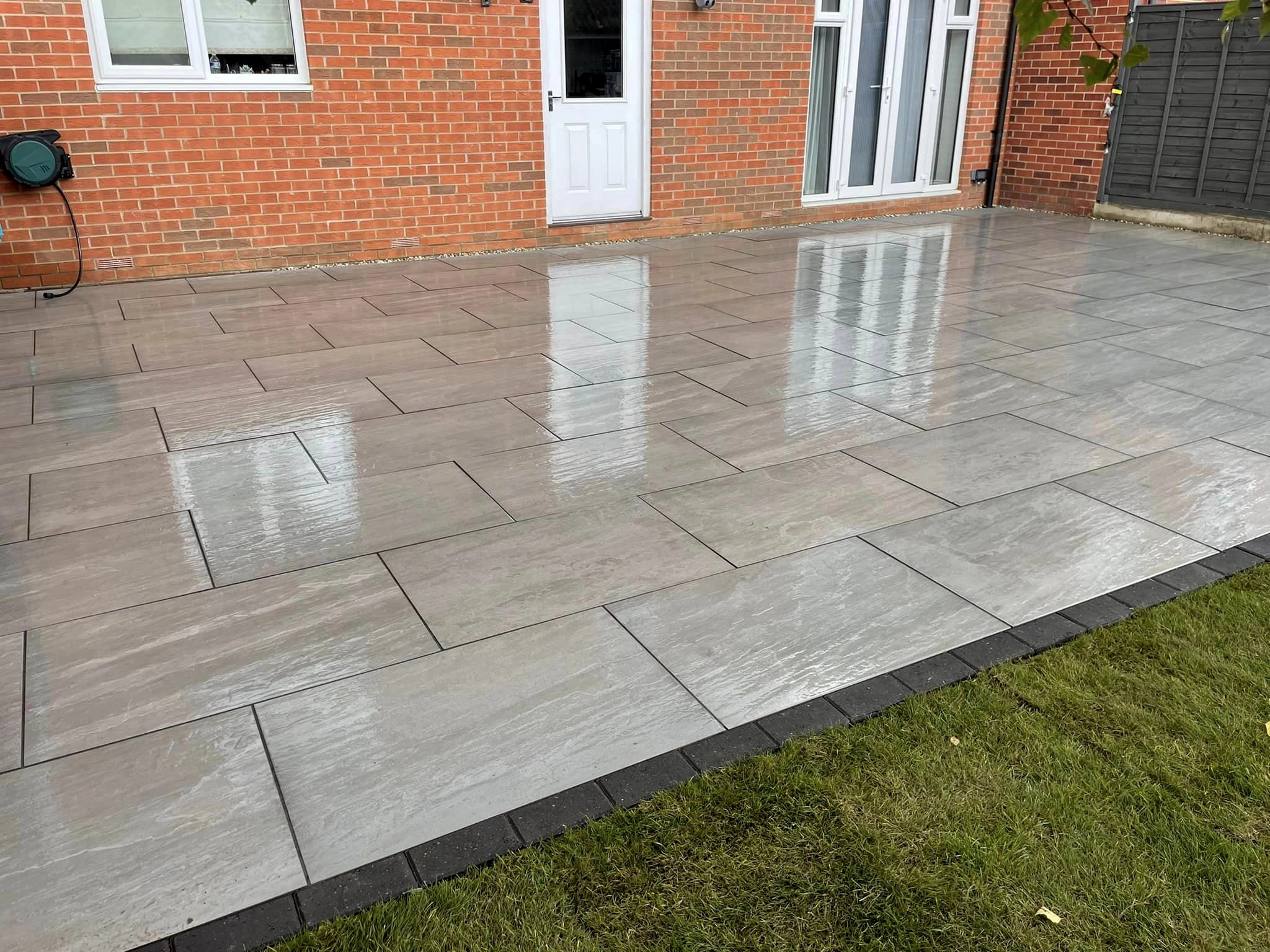 Grey porcelain slab patio with charcoal sett edging